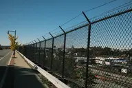 barbed_wire camera:fujifilm_x100 city exterior fence orientation:landscape photographer:deaddeaddeath road sidewalk sky // 1728x1152 // 432KB